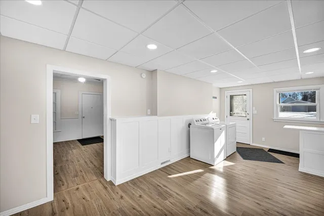 a view of a big room with wooden floor and windows