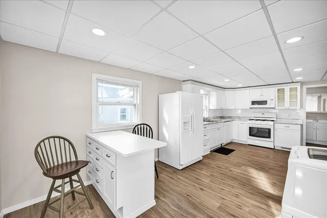 a kitchen with white cabinets and white appliances