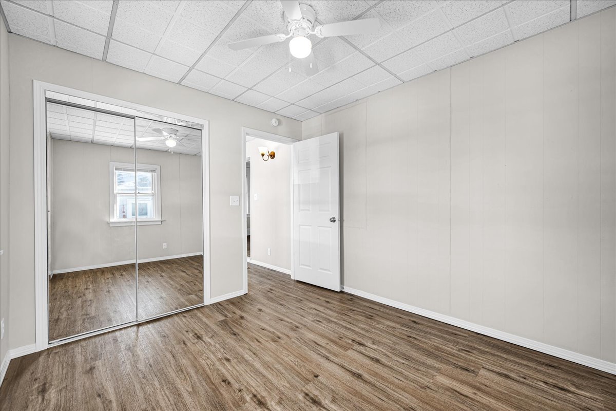 1406 West Walnut Street Bloomington, IL 61701 - Photo 15 of 32 an empty room with wooden floor cabinet and windows