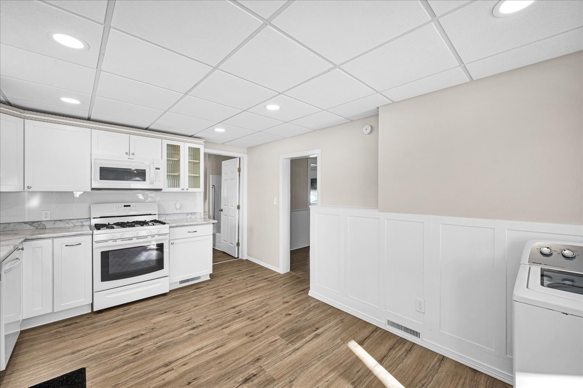 1406 West Walnut Street Bloomington, IL 61701 - Photo 10 of 32 a kitchen with stainless steel appliances white cabinets and wooden floor