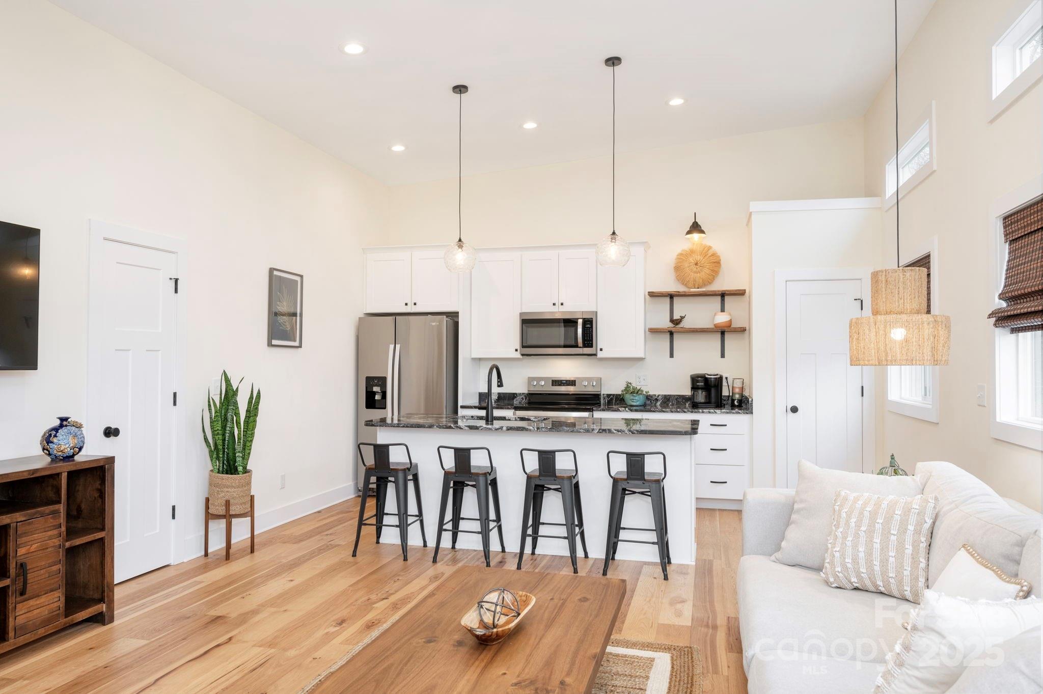 20 Garden Road Asheville, NC 28804 - Photo 11 of 44 a kitchen with stainless steel appliances a table chairs refrigerator and microwave