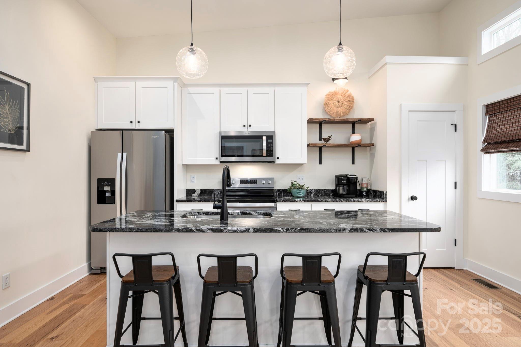20 Garden Road Asheville, NC 28804 - Photo 14 of 44 a kitchen with stainless steel appliances granite countertop a dining table chairs refrigerator and microwave