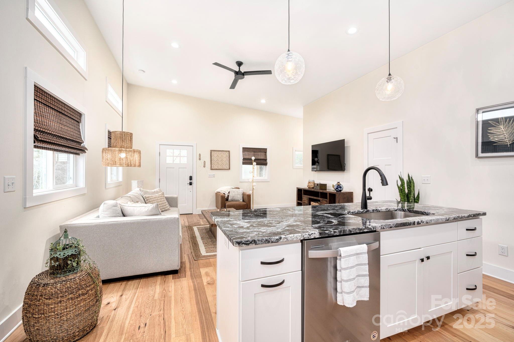 20 Garden Road Asheville, NC 28804 - Photo 15 of 44 a kitchen with stainless steel appliances granite countertop a stove a sink dishwasher a dining table and chairs with wooden floor