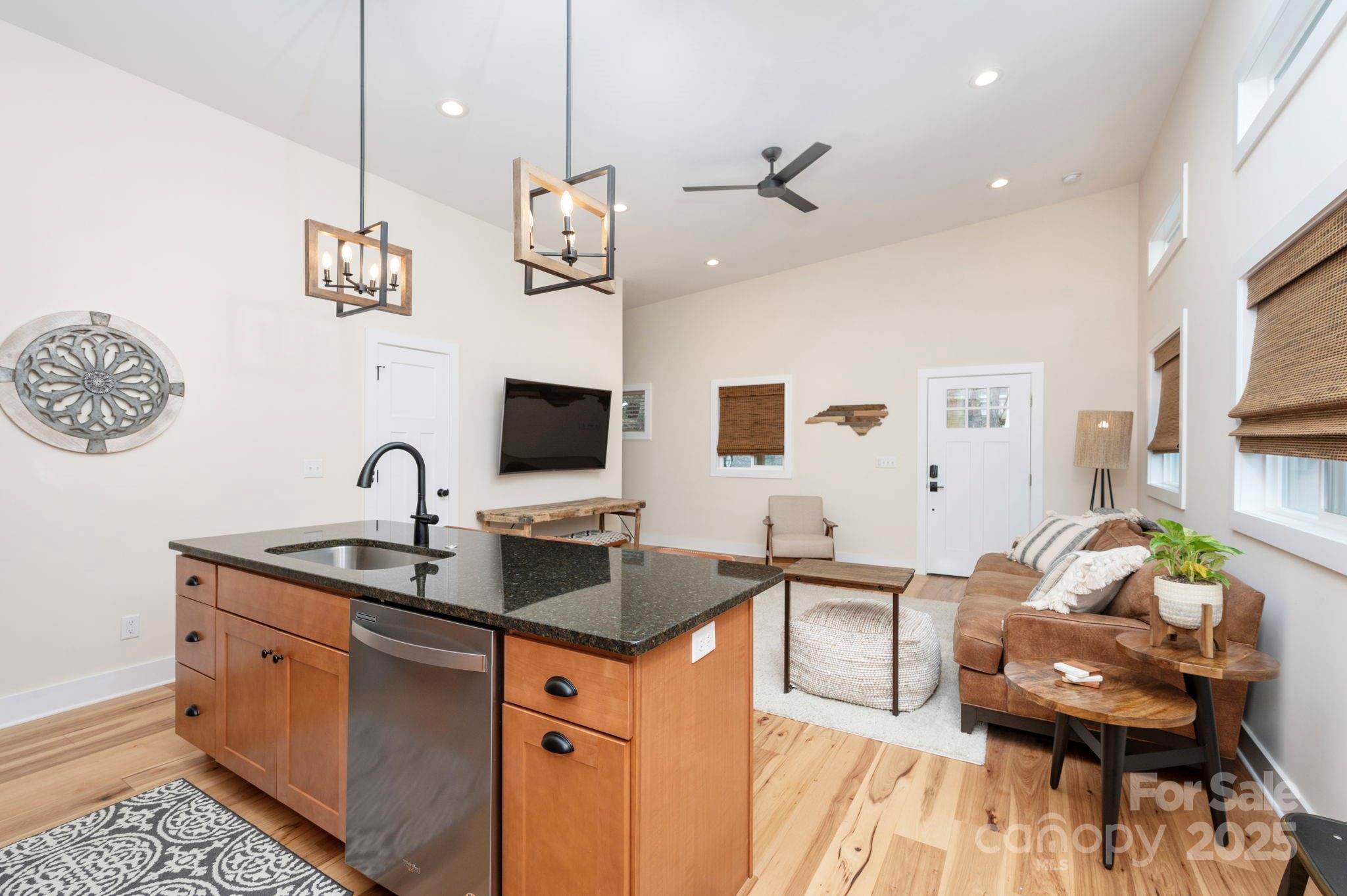 20 Garden Road Asheville, NC 28804 - Photo 34 of 44 a dining hall with stainless steel appliances granite countertop couches a fireplace a flat screen tv and a dining table