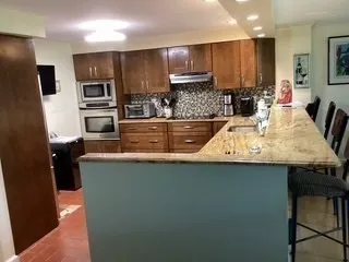 a kitchen with stainless steel appliances granite countertop a sink refrigerator and microwave