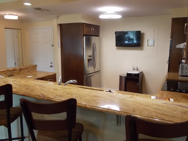 a kitchen with stainless steel appliances granite countertop a stove a sink a microwave a refrigerator and cabinets