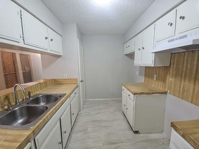 a kitchen with granite countertop a sink and cabinets