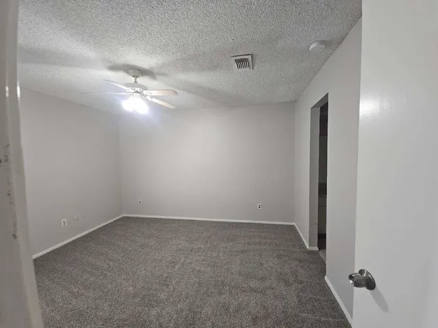 an empty room with a ceiling fan and a window