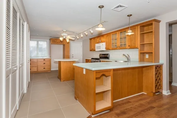 a kitchen that has a lot of cabinets in it and wooden floor