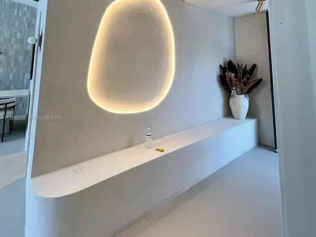 a room with a table a chandelier and living area