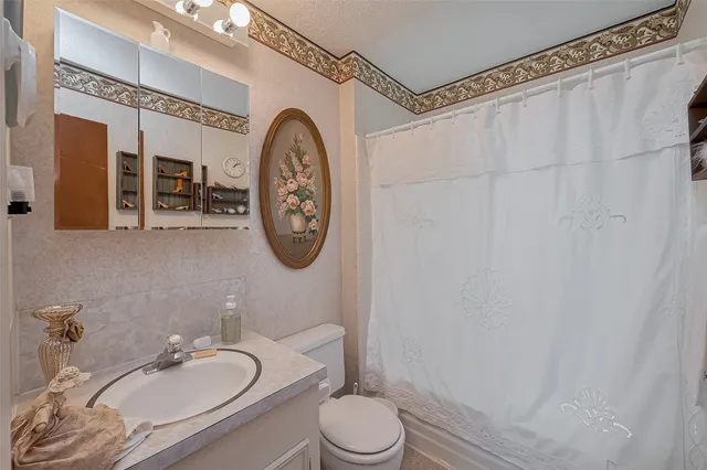 a bathroom with a granite countertop sink mirror vanity and toilet