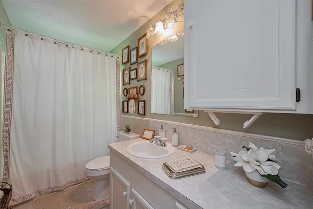 a bathroom with a sink vanity granite and toilet