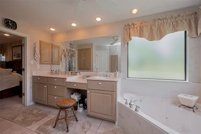 a bathroom with a tub sink and mirror