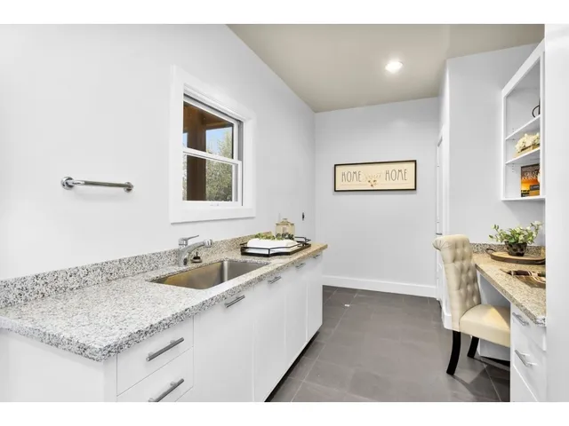 a kitchen with a sink cabinets and wooden floor