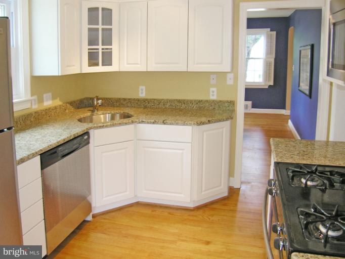 9511 Monroe Street Silver Spring, MD 20910 - Photo 8 of 22 a kitchen with stainless steel appliances granite countertop a stove a sink and a microwave