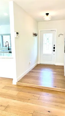 a view of a room that has a sink and wooden floor