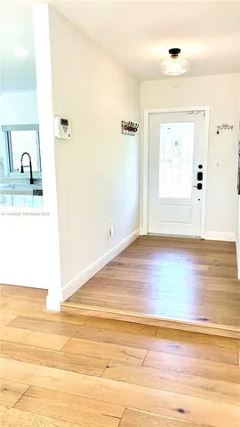 a view of a room that has a sink and wooden floor