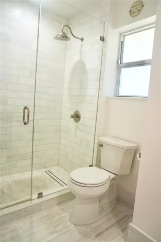 a white toilet sitting next to a shower
