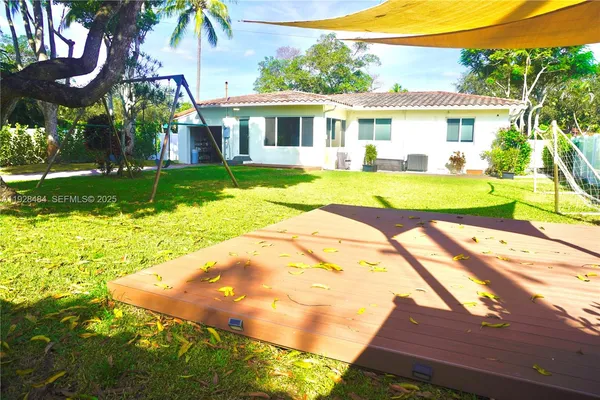 a view of a house with yard and swimming pool