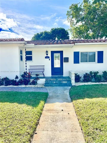 a front view of a house with a garden and yard