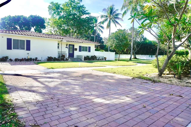 a view of a house with pool and trees in the background