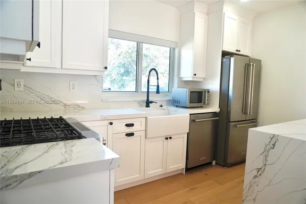 a kitchen with stainless steel appliances granite countertop a sink stove and refrigerator