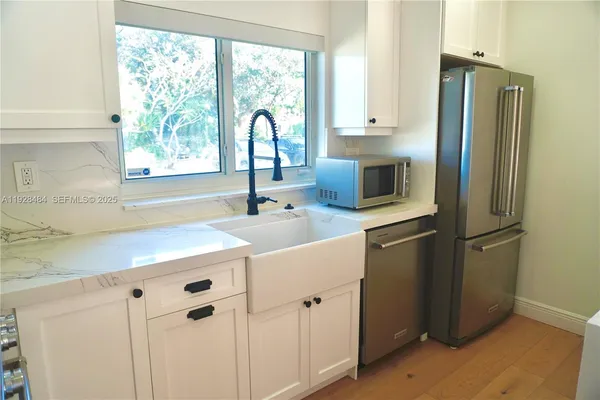 a kitchen with appliances a sink and a counter space