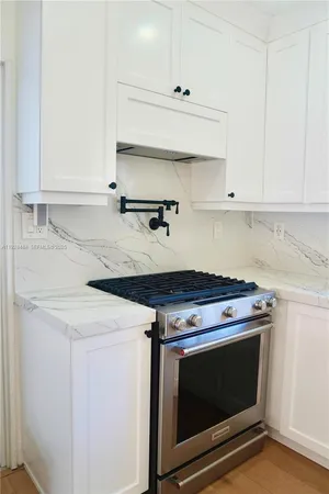 a kitchen with granite countertop a stove and a sink