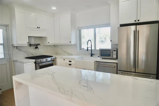 a kitchen with stainless steel appliances a refrigerator sink and cabinets