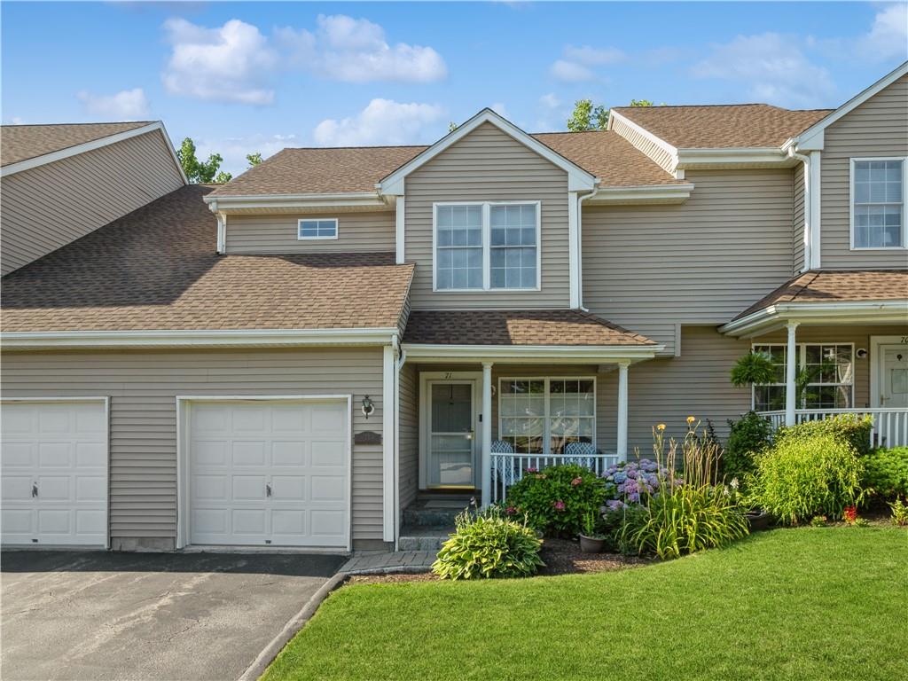View of front of home with a porch, a garage, and a front yard