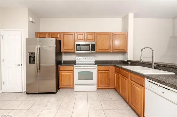 a kitchen with stainless steel appliances granite countertop a refrigerator and a stove top oven