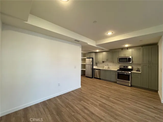 a large kitchen with stainless steel appliances granite countertop a stove a sink and a refrigerator