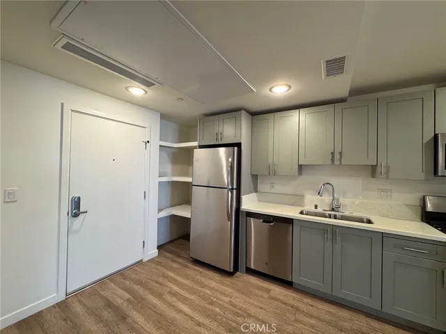 a kitchen with a sink a refrigerator and cabinets