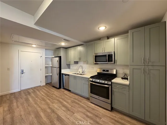 a kitchen with stainless steel appliances kitchen island granite countertop a refrigerator and a stove top oven
