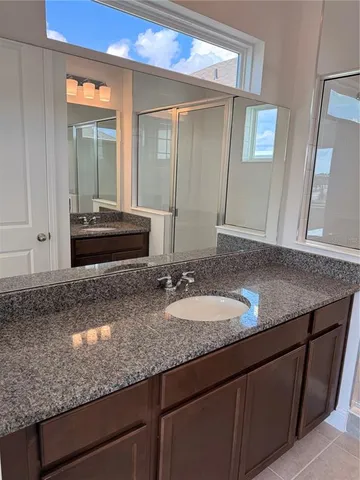a bathroom with a granite countertop sink and a mirror