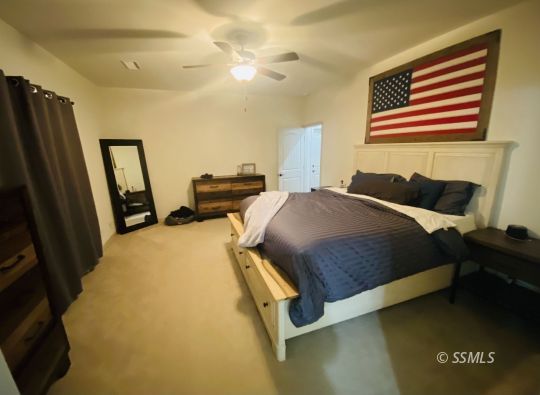 124 Rancho Del Cerro Ridgecrest, CA 93555 - Photo 11 of 21 a bedroom with a bed and dresser with rug