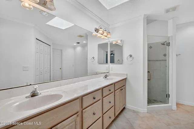 a spacious bathroom with a granite countertop double vanity sink a mirror and shower