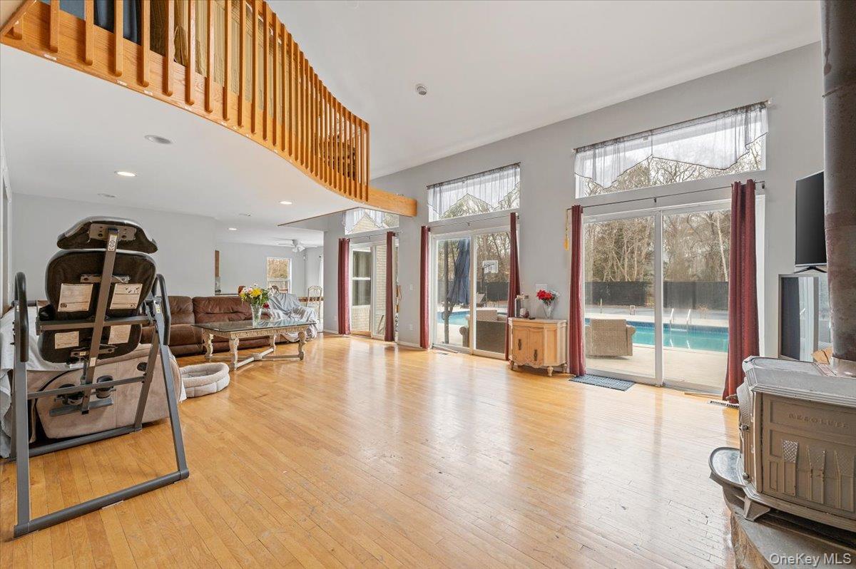 24 Wisteria Drive Remsenburg, NY 11960 - Photo 12 of 44 a view of a living room and dining room with furniture wooden floor windows and a livingroom view