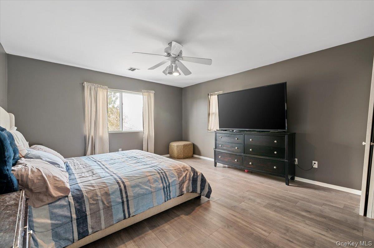 24 Wisteria Drive Remsenburg, NY 11960 - Photo 19 of 44 a bedroom with a bed and a flat screen tv on dresser