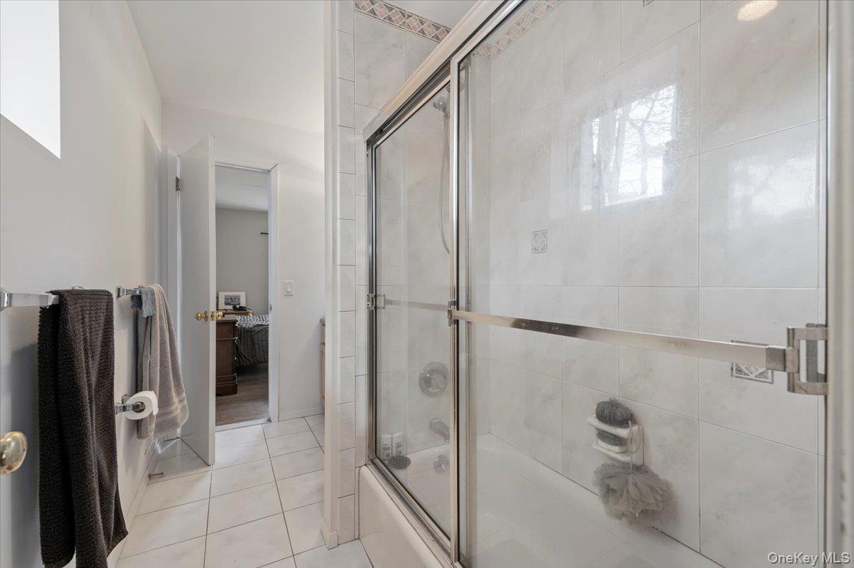 24 Wisteria Drive Remsenburg, NY 11960 - Photo 22 of 44 a bathroom with a shower and a glass door