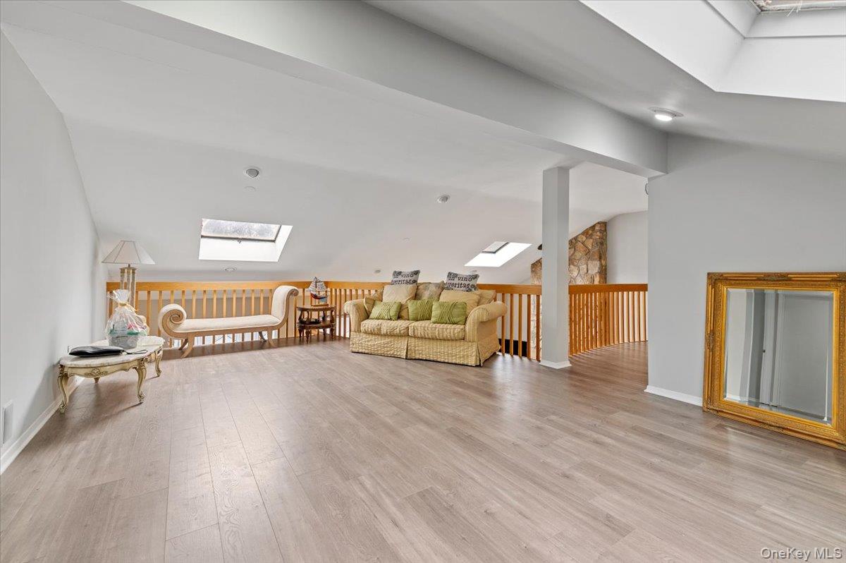 24 Wisteria Drive Remsenburg, NY 11960 - Photo 27 of 44 a living room with furniture and a wooden floor