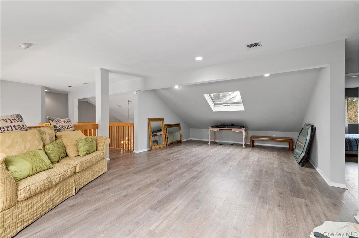 24 Wisteria Drive Remsenburg, NY 11960 - Photo 28 of 44 a living room with furniture and a wooden floor
