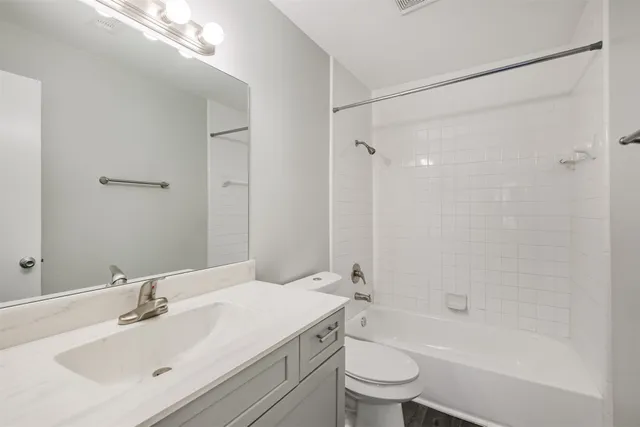 a view of an empty room with wooden floor and window
