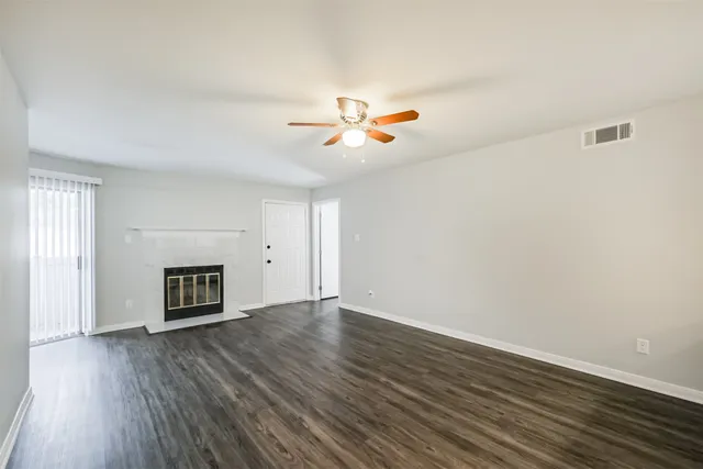 an empty room with a fireplace and wooden floor