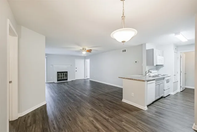 a kitchen with stainless steel appliances granite countertop a stove and white cabinets with wooden floor