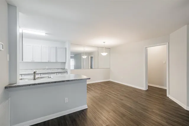 a kitchen with a sink cabinets and wooden floor
