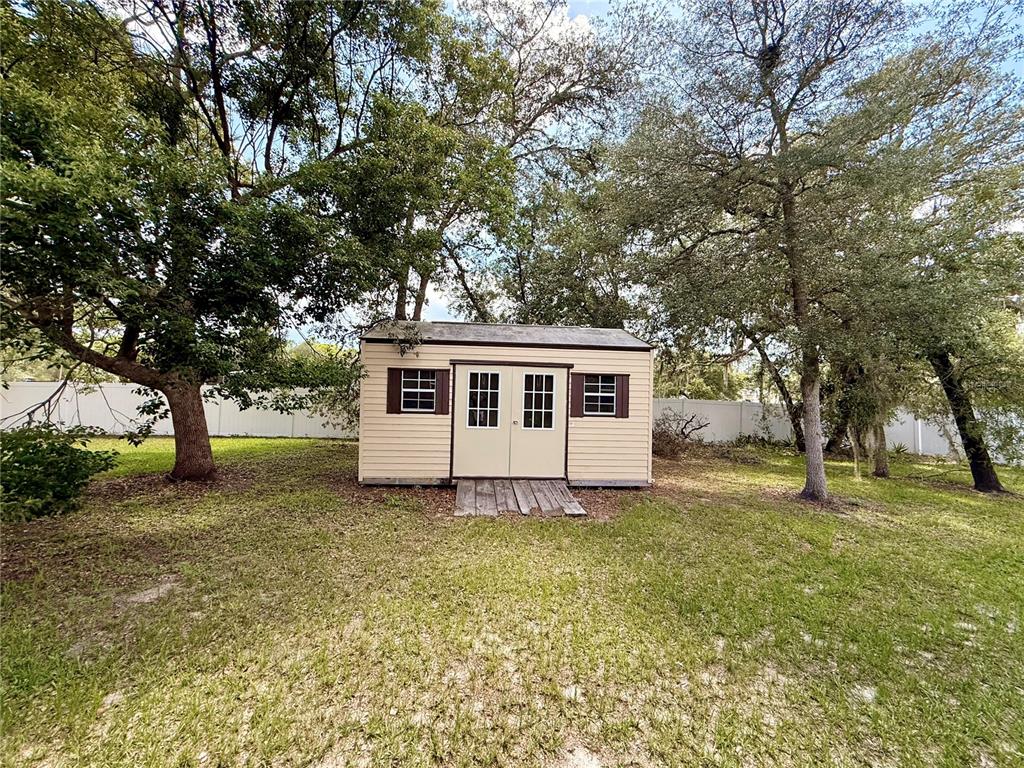 13110 Bamboo Street Spring Hill, FL 34609 - Photo 52 of 56 a white house that has a tree in front of a house