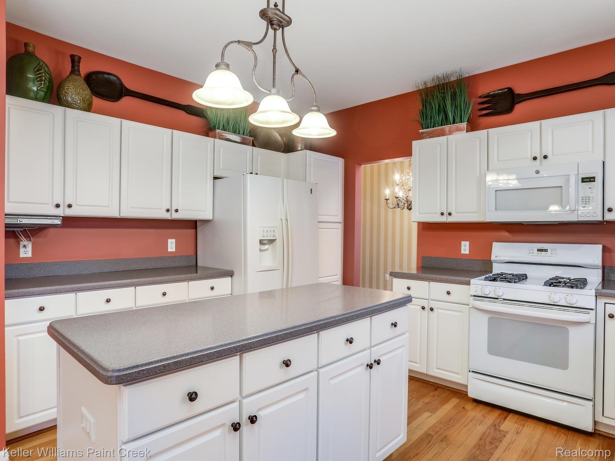Solid surface counters in the kitchen and continued wood flooring. 