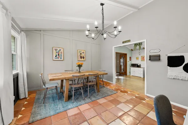 a dining room with wooden floor and a chandelier