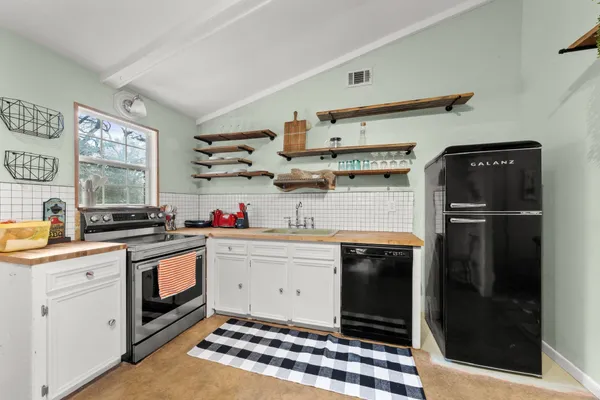 a kitchen with stainless steel appliances a stove a sink and a refrigerator